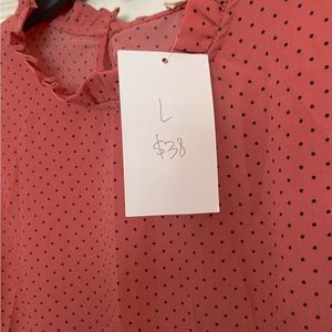 Coral blouse with black polka dots.